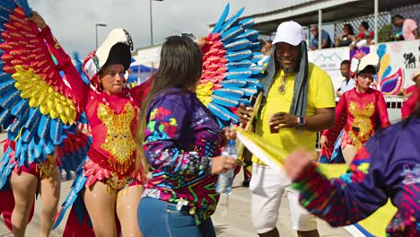 Einheimische-Aus-Der-Karibik-Schwenken-Flaggen-Und-Tanzen-In-Glitzernden-Kostümen-Bei-Einer-Parade