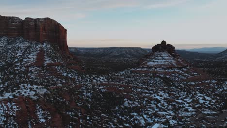 Rote-Felsformationen-Unter-Schnee-In-Sedona,-Arizona-Bei-Sonnenuntergang---Luftaufnahme-Einer-Drohne