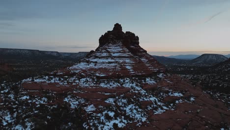 Rote-Felsformation-Mit-Schnee-In-Sedona,-Arizona-In-Der-Abenddämmerung---Drohnenaufnahme