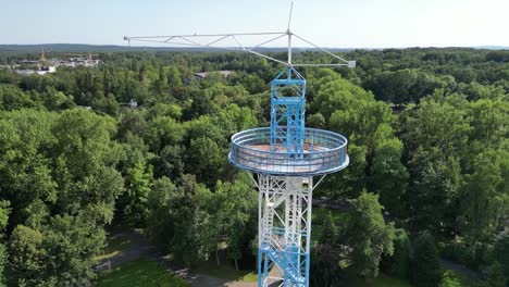 Aerial-Shot-of-Blue-and-White-Parachute-Tower-on-Sunny-Day