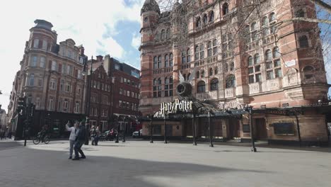 Couple-And-Tourists-Taking-Photo-In-Front-Of-The-Palace-Theatre-on-Shaftesbury-Avenue-in-London's-West-End-currently-showing-performances-of-the-popular-Harry-Potter-and-the-Cursed-Child