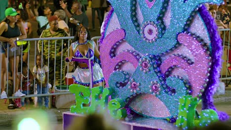 Shiny-sequin-lights-glow-on-parade-float-pushed-by-student-in-Carnival-parade-at-night
