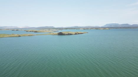 Drone-Siguiendo-Una-Toma-De-Las-Islas-Del-Lago-Myvatn,-Islandia-En-Un-Día-Nublado-Brillante