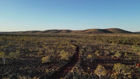 Aerial-establishing-shot-of-abandoned-road-in-Australian-desert-during-sunset-time