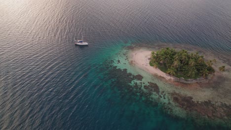 Drohnenaufnahme-Eines-Segelboots-Bei-Sonnenuntergang-Auf-Einer-Abgelegenen-Insel-Im-San-Blas-Archipel