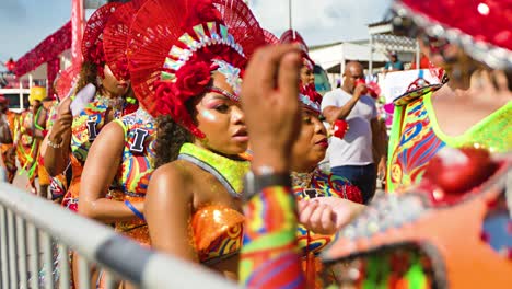 Performers-in-colorful-bodysuit-costumes-and-red-headdresses-walk-in-Carnaval-parade