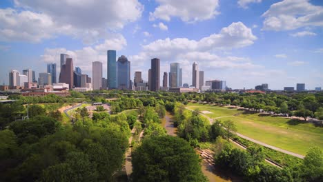 Ascending-drone-shot-revealing-downtown-Houston,-Texas-on-a-cloudy-but-sunny-day