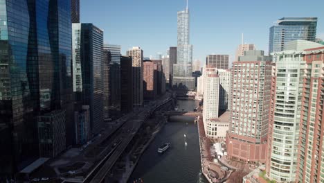 Long-aerial-reverse-shot-along-the-Chicago-River,-4K-drone-clip