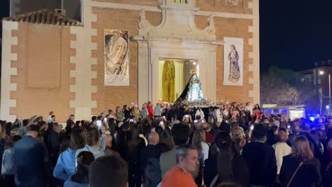 filming-of-the-exit-of-the-image-of-the-virgin-of-the-parish-through-the-main-door-held-by-parishioners,-there-is-a-large-crowd-of-faithful-in-the-procession-we-see-the-posters-of-the-event