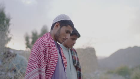 Young-Khuzdar-local-Male-With-red-white-Keffiyeh-shawl-standing-around,-looking-solemn