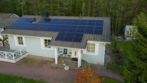 Aerial-view-around-a-detached-house-with-Photovoltaic-cells,-autumn-evening