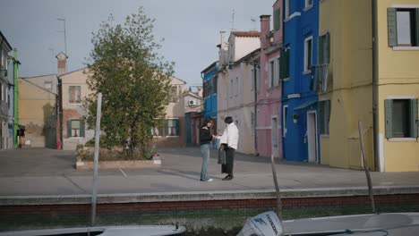 Tourists-capturing-colorful-Burano-scenery,-Italy