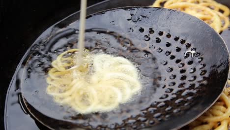 Close-up-of-sweet-Jollibee-Jalebi-being-fried-in-syrup