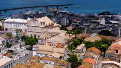 Aerial-view-of-Terreiro-de-Jesus-square-close-to-Pelourinho-with-colorful-buildings-and-the-sea-at-background,-Salvador,-Bahia,-Brazil