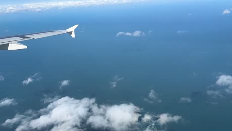 Aerial-view-from-a-plane:-Ocean,-clouds,-and-wing-captured-in-a-captivating-journey-through-the-skies