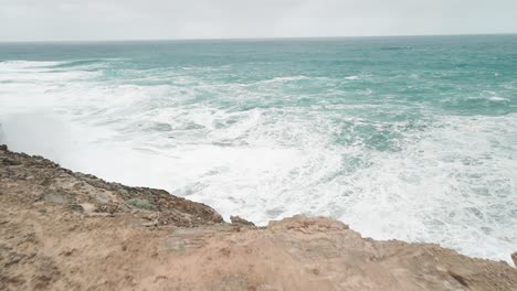 Forward-aerial-view-of-high-tides-hitting-the-coast-of-Cape-Bridgewater-in-Australia