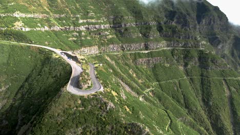 Madeira-Lombo-do-Mouro-viewpoint-curved-hairpin-road-aerial-view-across-steep-green-terraced-Madeira-mountain-slope