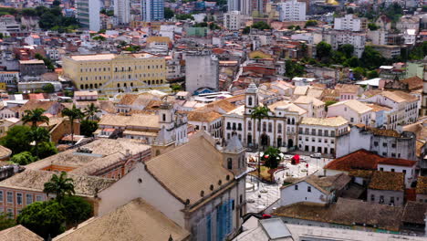 Luftaufnahme-Des-Terreiro-De-Jesus-Platzes-In-Der-Nähe-Von-Pelourinho-Mit-Farbenfrohen-Gebäuden-Und-Dem-Meer-Im-Hintergrund,-Salvador,-Bahia,-Brasilien