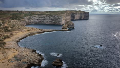 Vista-Aérea-De-La-Bahía-De-Dwejra-Con-Espectaculares-Formaciones-Costeras-En-Un-Día-Nublado