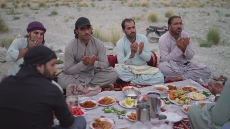 Group-of-people-praying-before-Ramadan-iftar-drive-in-Khuzdar,-Balochistan,-Pakistan