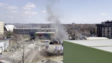 Wide-shot-of-Firefighters-Fighting-exploded-Truck-in-Montreal,-Saint-Michel