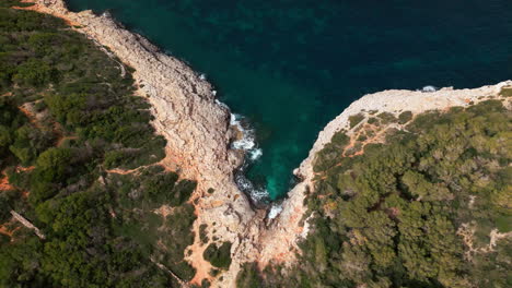 Luftaufnahme-Der-Zerklüfteten-Küste-Mallorcas-Mit-Türkisfarbenem-Wasser