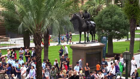 Grandes-Multitudes-De-Personas-Se-Reúnen-En-El-Centro-De-La-Ciudad-De-Brisbane,-Llenas-De-Anticipación-Antes-Del-Comienzo-Del-Tradicional-Desfile-Anual-Del-Día-De-Anzac-En-La-Plaza-Anzac.