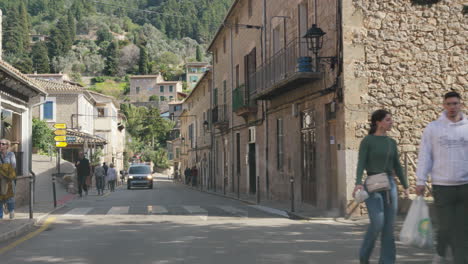 Quiet-street-scene-in-Deia,-Mallorca-with-pedestrians-and-vehicles