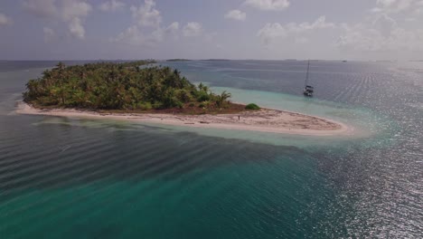 Drone-shot-from-a-remote-island-in-San-Blas-Archipelago-with-a-woman-walking-in-the-shore