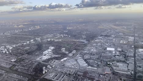 Aerial-view-of-Toronto-Industrial-area-as-seen-from-airplane-approaching-Pearson-airport-with-runway-in-background,-Ontario-in-Canada