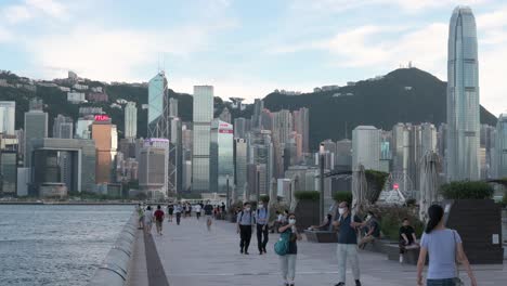 La-Gente-Pasea-Por-El-Paseo-Marítimo-De-Victoria-Mientras-El-Horizonte-De-Hong-Kong-Se-Ve-Al-Fondo