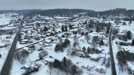 Aerial-view-of-a-snow-covered-rural-town-with-roads-intersecting-between-houses
