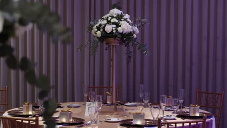 Round-banquet-table-for-wedding-guests-decorated-with-fresh-flowers-and-crystal-cutlery