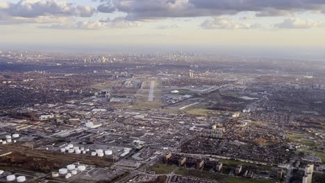 Aerial-view-of-Toronto-airport-area-as-seen-from-airplane-approaching-Pearson-airport-with-runway-for-landing-in-background,-Ontario-in-Canada