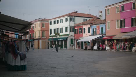 Quiet-Burano-square-with-colorful-shops,-Venice-Italy