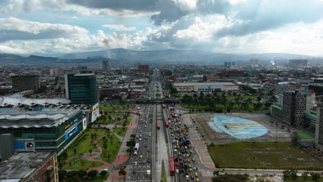 Aerial-view-backwards-over-traffic-on-the-Avenida-NQS-in-cloudy-Bogota,-Colombia