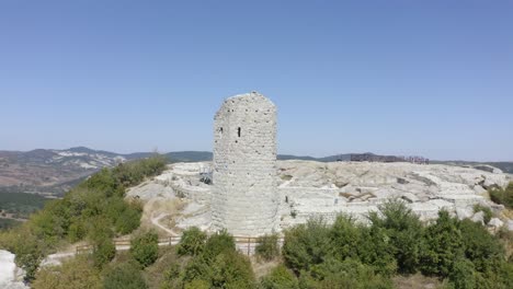 Drone-orbiting-around-the-palace-complex-of-the-ancient-historical-landmark-of-Perperikon,-showing-a-high-tower-with-a-viewdeck,-located-in-the-province-of-Kardzhali-in-Bulgaria
