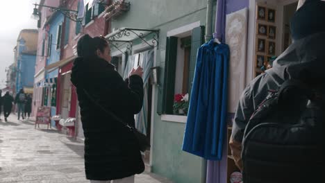 Street-view-of-shoppers-in-winter-on-Burano,-Italy