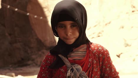 portrait-shot-of-a-cute-little-girl-with-sad-face-and-traditional-clothes-in-the-gorges-of-dades