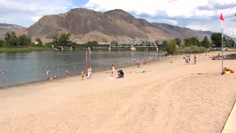 Montañas-Desérticas-Y-Playa-Fluvial-Con-Bañistas