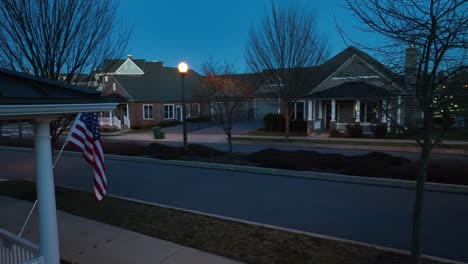 American-flag-on-modern-55+-house-with-Tesla-EV-driving-past