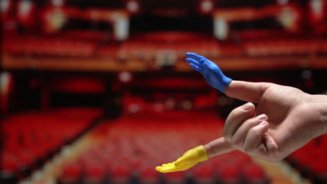 Tiny-hand-puppet-clapping-in-an-empty-theater
