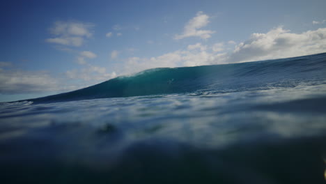 Agua-Azul-Turquesa-En-La-Superficie-Del-Océano-Mientras-La-Ola-Rompe-En-Un-Barril-Profundo