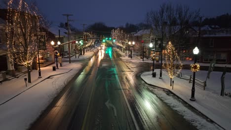 Calle-Crepuscular-Con-Luces-Festivas,-Aceras-Nevadas-Y-Tráfico-Nocturno