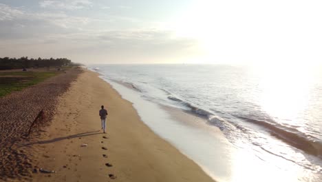 Persona-Corriendo-Por-La-Playa-Vacía-De-Pondicherry-Durante-La-Hora-Dorada