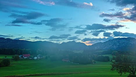 Colorido-Paisaje-De-Lapso-De-Tiempo-Alpes-Austríacos-Campo-Europeo-Horizonte-Nubes-En-Movimiento,-Tarde-Convirtiéndose-En-Anochecer,-Rayos-De-Sol-Sobre-Los-Campos-Verdes-De-Los-Agricultores