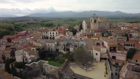 Luftaufnahme,-Die-über-Die-Dächer-Der-Stadt-Peralada-In-Girona,-Costa-Brava,-In-Richtung-Der-Kirche-Sant-Martí-Fliegt