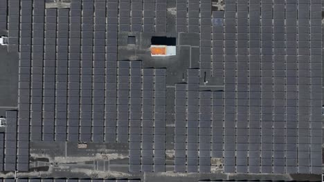 Toma-Aérea-De-Arriba-Hacia-Abajo-De-Paneles-Solares-En-Un-Gran-Edificio-De-Un-Centro-Comercial