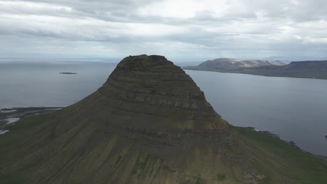 Drone-flight-reveal-Grundarfjörður-fjord-behind-iconic-Kirkjufell-mountain