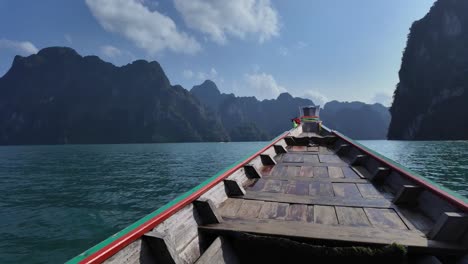 Schnelles-Traditionelles-Holzboot-Segelt-über-Das-Wasser-Zwischen-Malerischen-Tropischen-Bergen-Im-Khao-Sok-Nationalpark,-Thailand